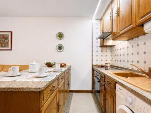 a kitchen with wooden cabinets and a sink at Refúgio do Vidoeiro in Geres