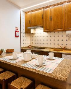 a kitchen with a table with cups and saucers on it at Refúgio do Vidoeiro in Geres +18 photos