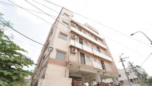 a tall white building with a balcony at Peelamedu PSG Tech Near Rooms in Coimbatore