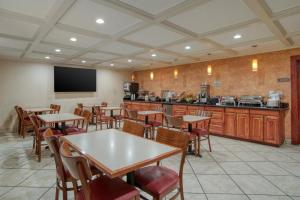a restaurant with tables and chairs and a kitchen at Best Western Vicksburg in Vicksburg