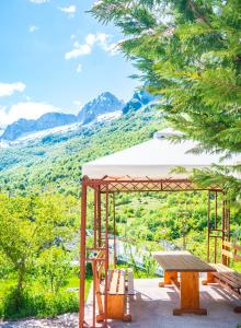 a picnic table and bench with a view of a mountain at Arditis Cozy Studio in Bogë +2 photos