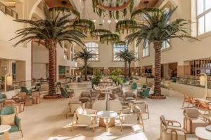 a lobby with palm trees and tables and chairs at Hyatt Zilara Cancun - All Inclusive - Adults Only in Cancún