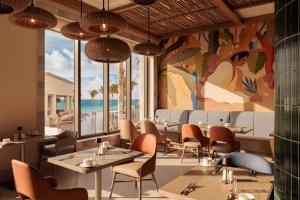 a restaurant with tables and chairs and a mural at Hyatt Zilara Cancun - All Inclusive - Adults Only in Cancún