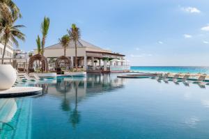 a resort swimming pool with chairs and the ocean at Hyatt Zilara Cancun - All Inclusive - Adults Only in Cancún