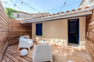 a patio with white chairs and a table at Le Céleste - Suite romantique immersive climatisée, sauna et spa privatif in Lesparre-Médoc
