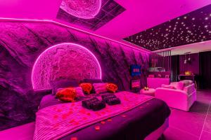 a purple bedroom with a bed with a pink ceiling at Le Céleste - Suite romantique immersive climatisée, sauna et spa privatif in Lesparre-Médoc