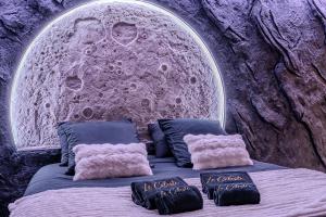 a room with a bed with a stone wall at Le Céleste - Suite romantique immersive climatisée, sauna et spa privatif in Lesparre-Médoc