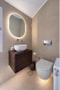 a bathroom with a sink and a toilet and a mirror at Valeria's Apartment in Argostoli +1 photo