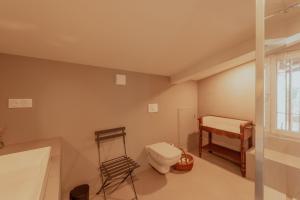 a bathroom with a toilet and a bed and a window at Vila Cabanes 46 in Le Montat +30 photos