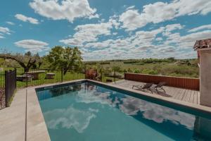 a swimming pool with a deck and a patio at Vila Cabanes 46 in Le Montat