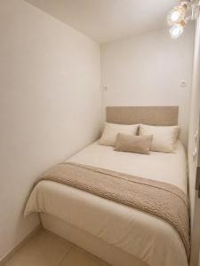 a small bedroom with a bed with white walls at Location Cap d'Agde Aurélie in Cap d'Agde +27 photos