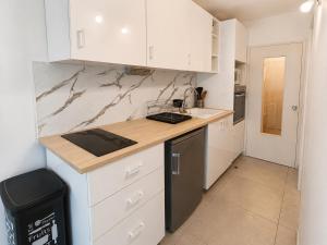 a kitchen with white cabinets and a counter top at Location Cap d'Agde Aurélie in Cap d'Agde