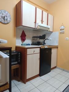 a kitchen with white cabinets and a black dishwasher at Πλάτανος Στούντιο ΙΙΙ PLATANOS STUDIO III in Mytilene