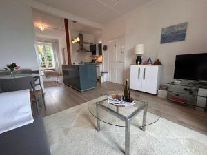 a living room with a bottle of wine on a glass table at St Guenole' Studio Apartment in Landévennec +2 photos