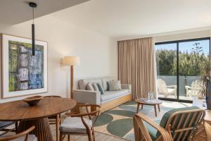 a living room with a couch and a table and chairs at Memmo Baleeira - Design Hotels in Sagres
