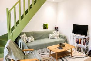 a living room with a green couch and a table at Duplex cosy 4-6 pers - Terrasse - Grenoble - Vercors in Claix