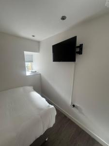 a bedroom with a bed and a flat screen tv on the wall at The Dublin Packet Double Room Number 8 in Holyhead