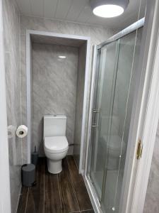 a bathroom with a toilet and a glass shower at The Dublin Packet Double Room Number 8 in Holyhead