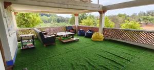 an outdoor patio with a table and chairs on a balcony at Bunk You Hostel Gokarna - AC Dorms in Gokarna