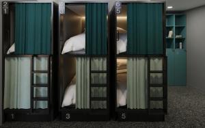 a room with three bunk beds with green curtains at Auberge du Parc in Delémont