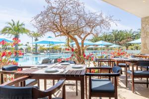 a restaurant with tables and chairs and a pool at Palmilla Dunes Luxury Residences in San José del Cabo