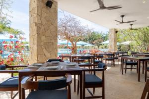 a restaurant with tables and chairs with a view of the water at Palmilla Dunes Luxury Residences in San José del Cabo