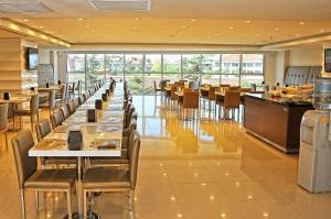 un restaurante con una larga fila de mesas y sillas en Ozpark Hotel, en Aksehir