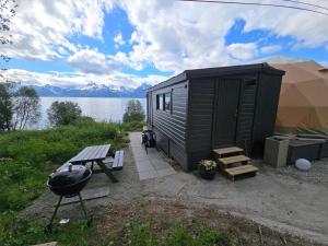 a black tiny house sitting next to a lake at Lyngenfjord View in Engnes
