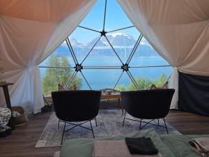 a room with two chairs and a large glass window at Lyngenfjord View in Engnes