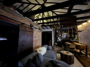 a living room with a couch and a brick wall at Къща за гости Mia Maria in Tutrakan