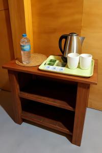 a tray with a water bottle and two cups on a table at Vercour Tree House Cabana Sigiriya in Sigiriya