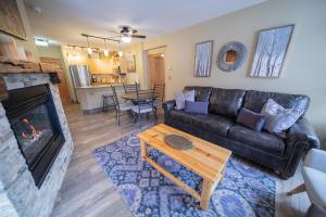 a living room with a black leather couch and a fireplace at Silver Mill 8228 by SummitCove Lodging in Colorado in Keystone