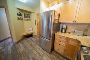 a kitchen with a stainless steel refrigerator and wooden cabinets at Silver Mill 8228 by SummitCove Lodging in Colorado in Keystone