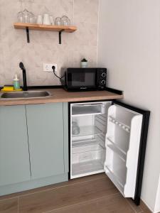 a kitchen with a microwave and an open refrigerator at Loft Jacuzzi Algarrobo in Arcos de la Frontera