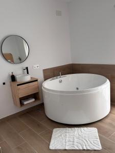 a white bath tub in a bathroom with a mirror at Loft Jacuzzi Algarrobo in Arcos de la Frontera +23 photos