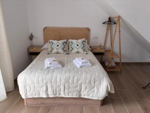 a bedroom with a bed with two towels on it at Loft Jacuzzi Algarrobo in Arcos de la Frontera