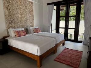 a bedroom with a bed with white sheets and pillows at Villa Mirada Maenam - Renovated Four Bedroom with Private Pool in Nathon Bay +26 photos