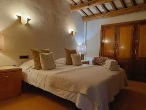 a bedroom with a large bed with white sheets at Cal Blasi in Montblanc