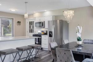 a kitchen with a refrigerator and a table with chairs at Spacious 5 Bed 2 bath House in Melrose Park