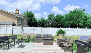 a patio with chairs and a grill in a yard at Spacious 5 Bed 2 bath House in Melrose Park