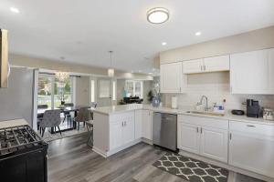 a kitchen with white cabinets and a dining room at Spacious 5 Bed 2 bath House in Melrose Park