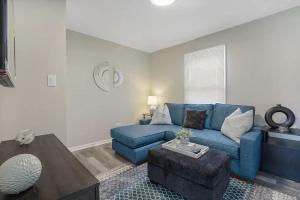 a living room with a blue couch and a table at Spacious 5 Bed 2 bath House in Melrose Park +30 photos