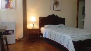 a bedroom with a bed and a table with a lamp at Residencial De Rosas in Santiago