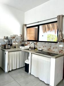 a kitchen with a sink and a window at Casa Pavezin in Mahahual +11 photos