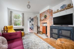 a living room with a fireplace and a tv at Twin Tides in Hythe