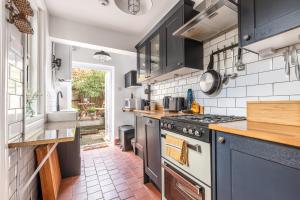 a kitchen with black cabinets and a stove top oven at Twin Tides in Hythe