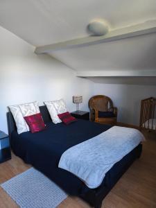 a bedroom with a large black bed with red pillows at Gite La Baraque in Najac