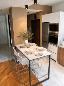 a kitchen with a white table and chairs in a room at FORUM Square in Skopje +8 photos