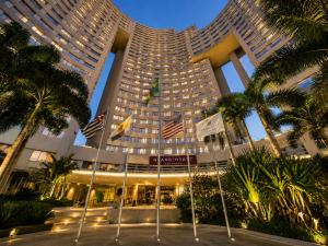 a large building with palm trees in front of it at Lapidare Flat Hotel Comfor Alphaville até 4 pessoas in Barueri