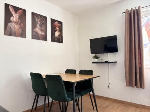 a dining room with a table and chairs and a tv at Ferienwohnung Am Pillersee in Sankt Ulrich am Pillersee